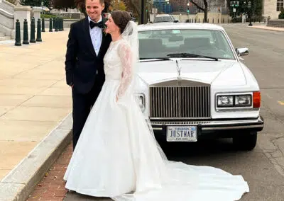 Photo of married couple in front of our white Rolls Royce